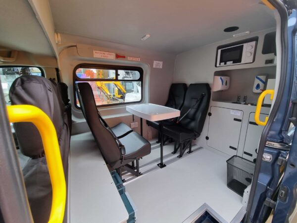 Wider angle of the seating and table in the rugged welfare van for hire